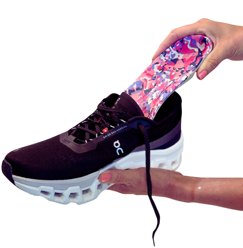 Person inserting a custom orthotic foot pad into a running shoe for added comfort and support